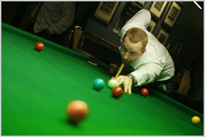 Person striking a billiard ball with the help of a cue stick